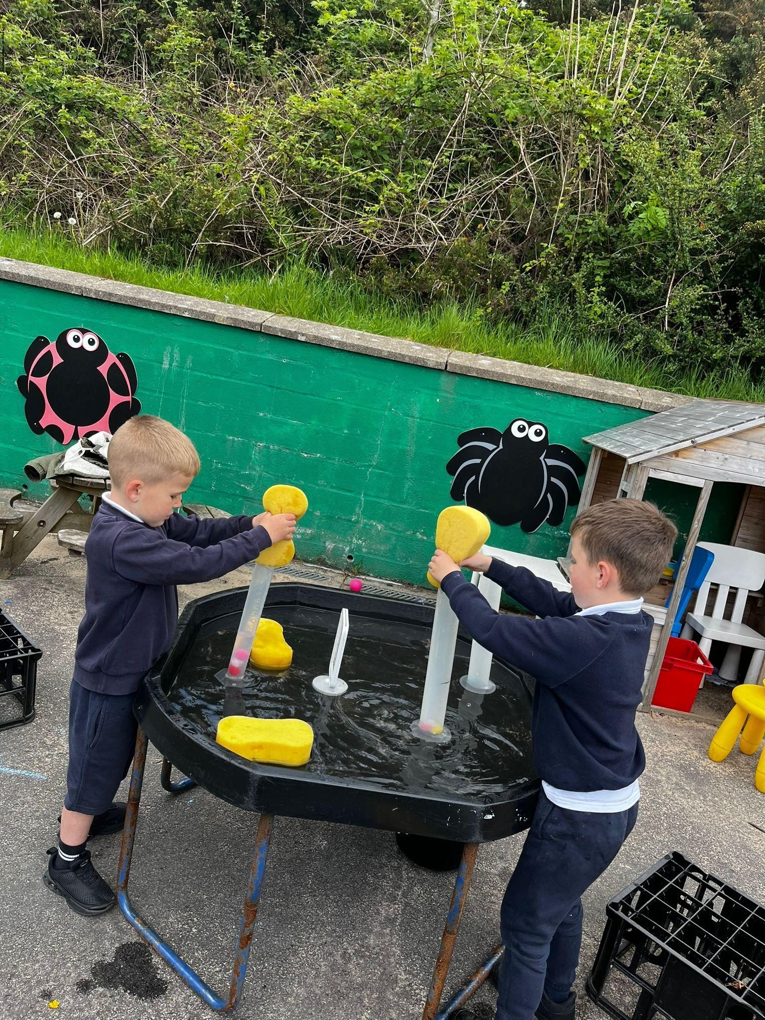 Pupils investigating water outdoors