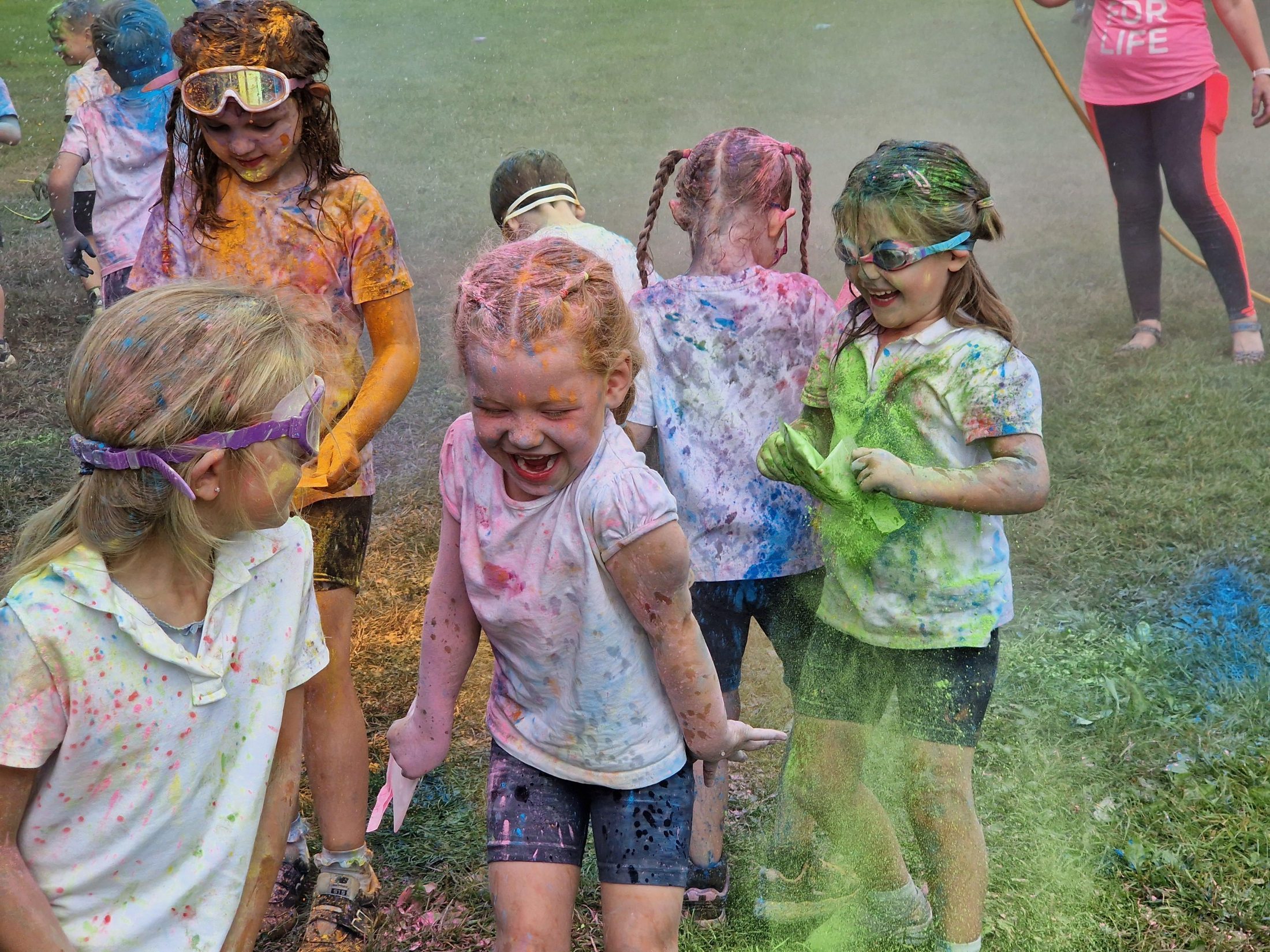Children laughing together during a colourful outdoor celebration
